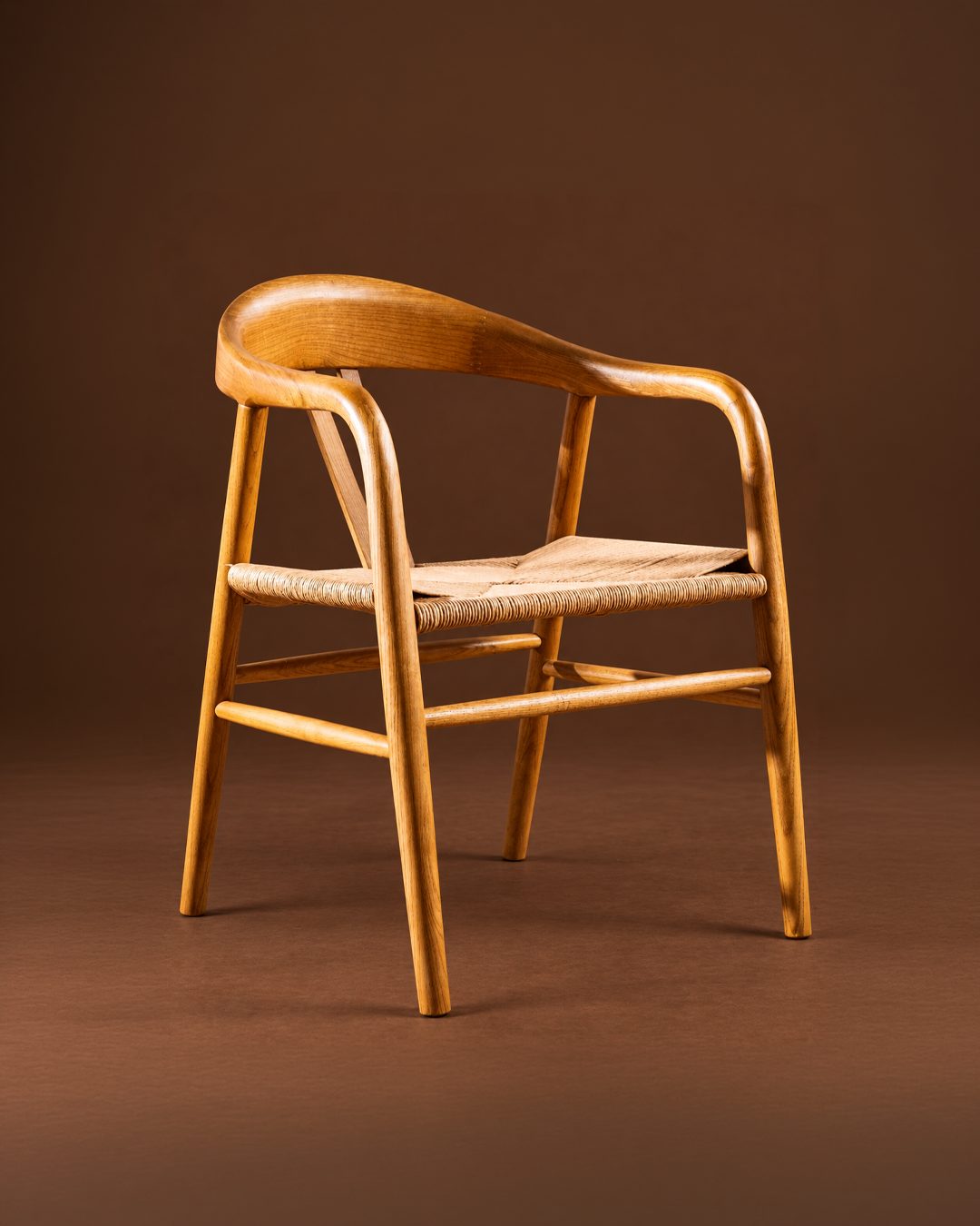 Silla de olmo con asiento de cuerda tejida, sobre fondo marrón